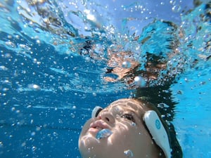 Child wearing an AquaSense headband underwater